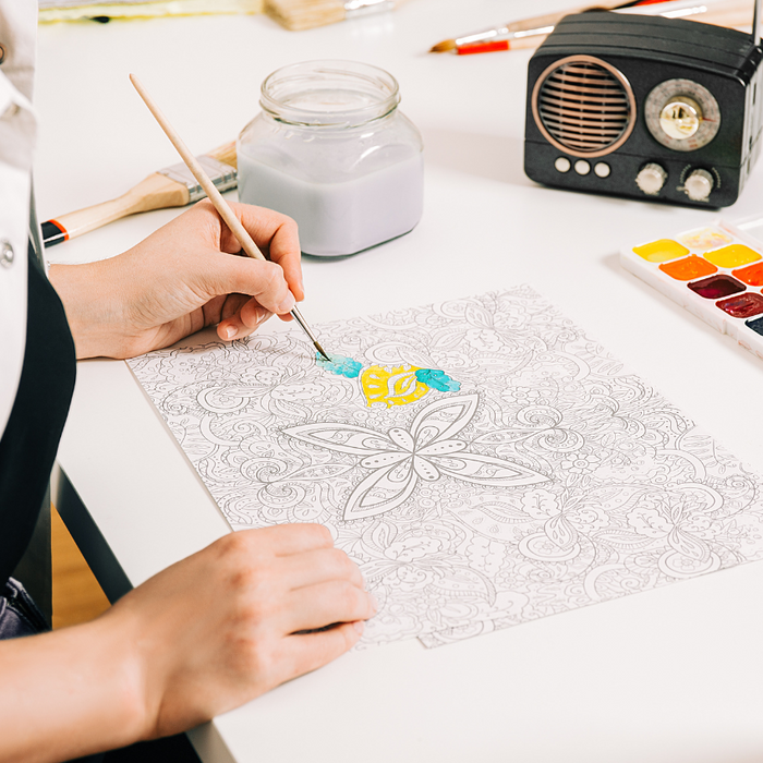 Image of a person painting a mindfulness picture at table