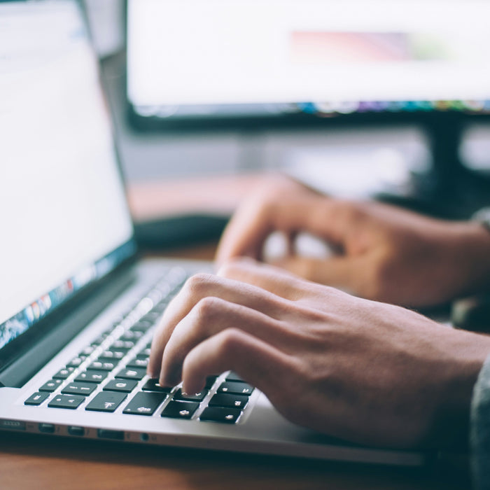 image of a laptop with a pair of hands typing