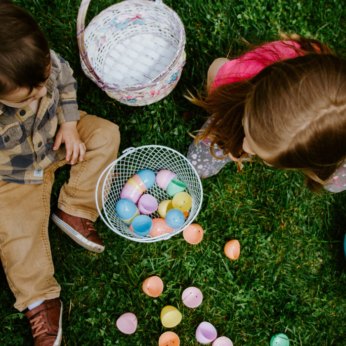 Overhead image of a boy and girl collecting Easter eggs in baskets