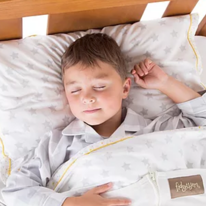 image of a young boy sleeping in a bed, wrapped up in compression bedding - fidgetbum