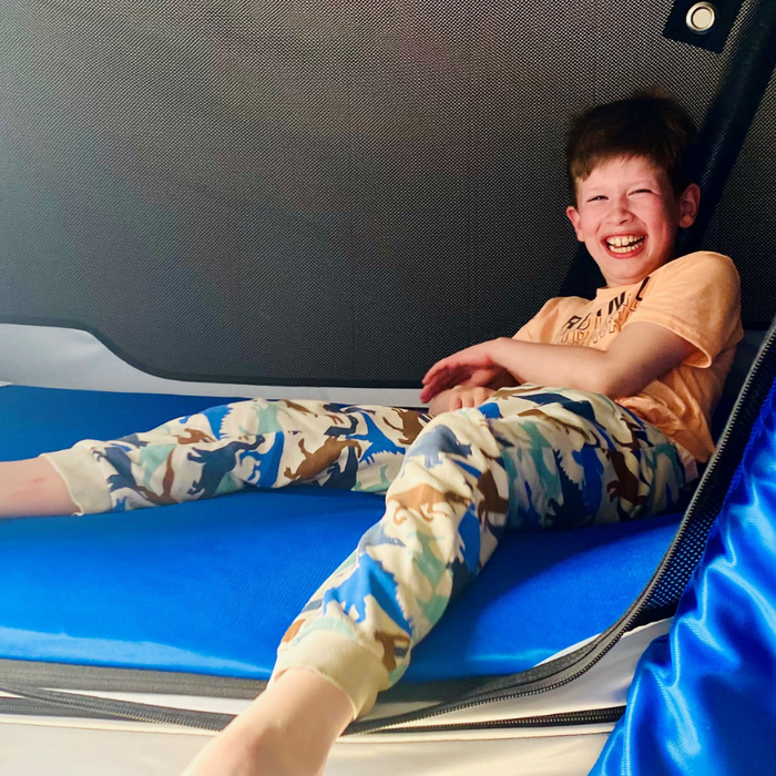 Smiling boy laying on specialist safety bed